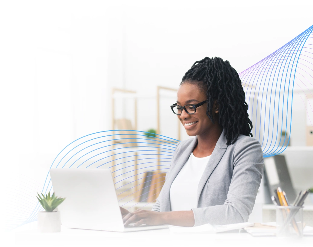 Smiling professional woman working on a laptop at her desk